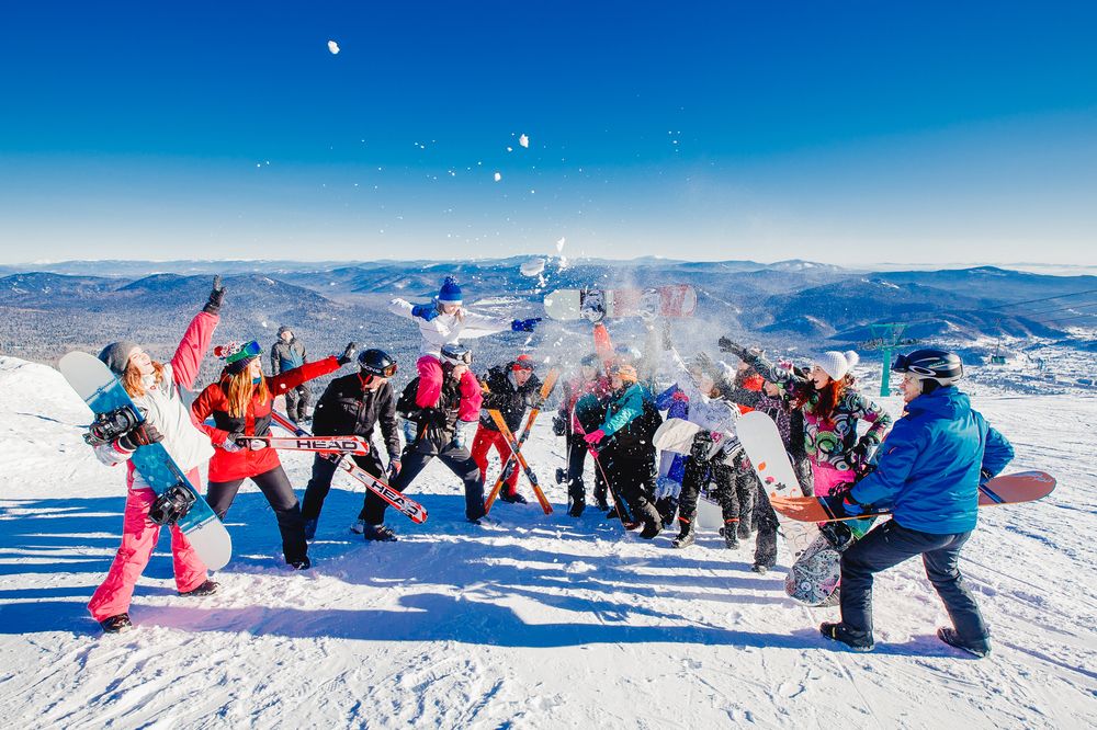 Cheerful company of skiers and snowboarders on the slope top in Sheregesh