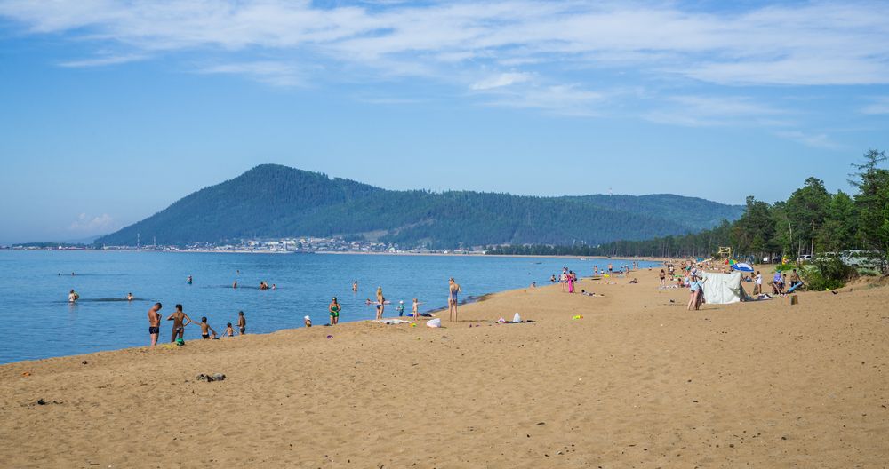 One of the sandy beaches on the eastern shore of Lake Baikal with tourists resting on it